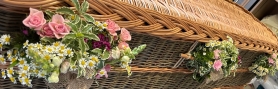 Posies on handles of wicker coffin