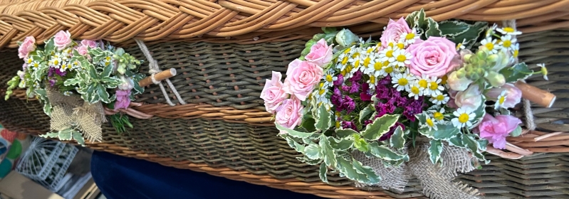 Posies on handles of wicker coffin