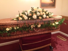Coffin spray and garland around wicker coffin