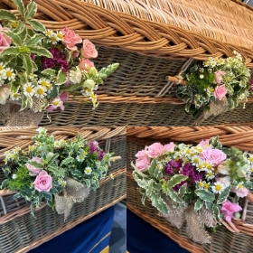 Posies on handles of wicker coffin